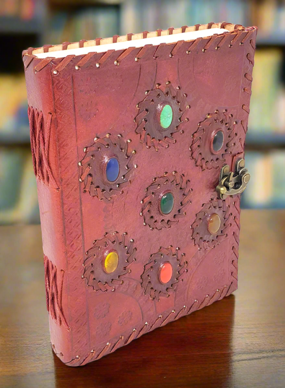 handmade leather journal with 7 stones embossed in the cover representing the seven chakras. Made with organic tree free paper