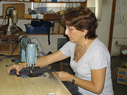 Seamstress in El-Salvador sewing upcycled rubber tire tubes to create unique eco-friendly handbags.